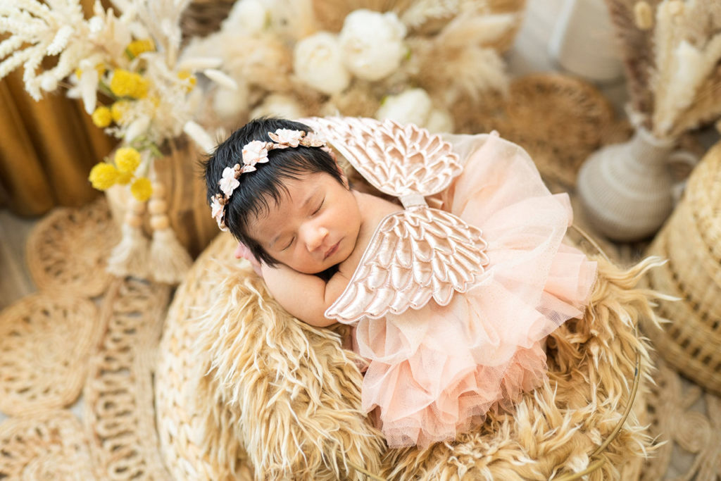 Valentina Meza-Kohnenkampf, a Dallas-Fort Worth newborn photographer, captures a sleeping baby girl in a basket.