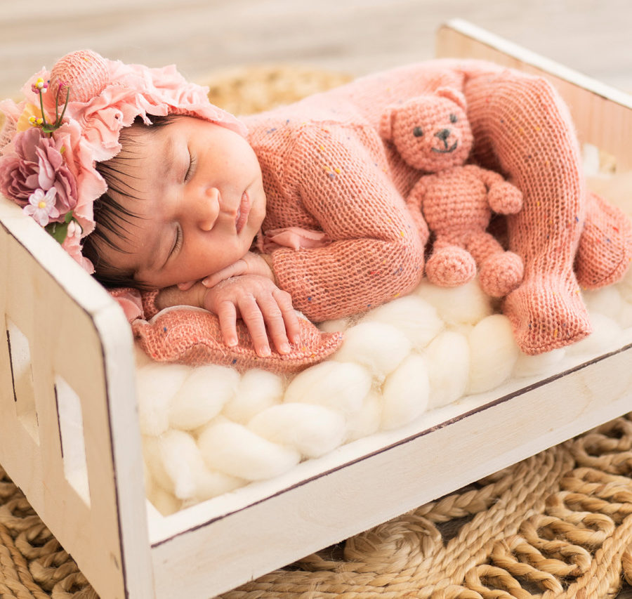 A newborn is sleeping in a wooden crate captured by Valentina Meza-Kohnenkampf, through her newborn photography package.